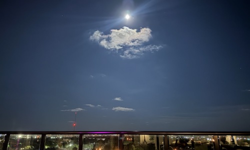 a balcony view of a city in the moonlight