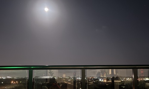 a balcony view of a city in the moonlight