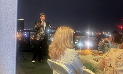 a man singing at an event with people watching