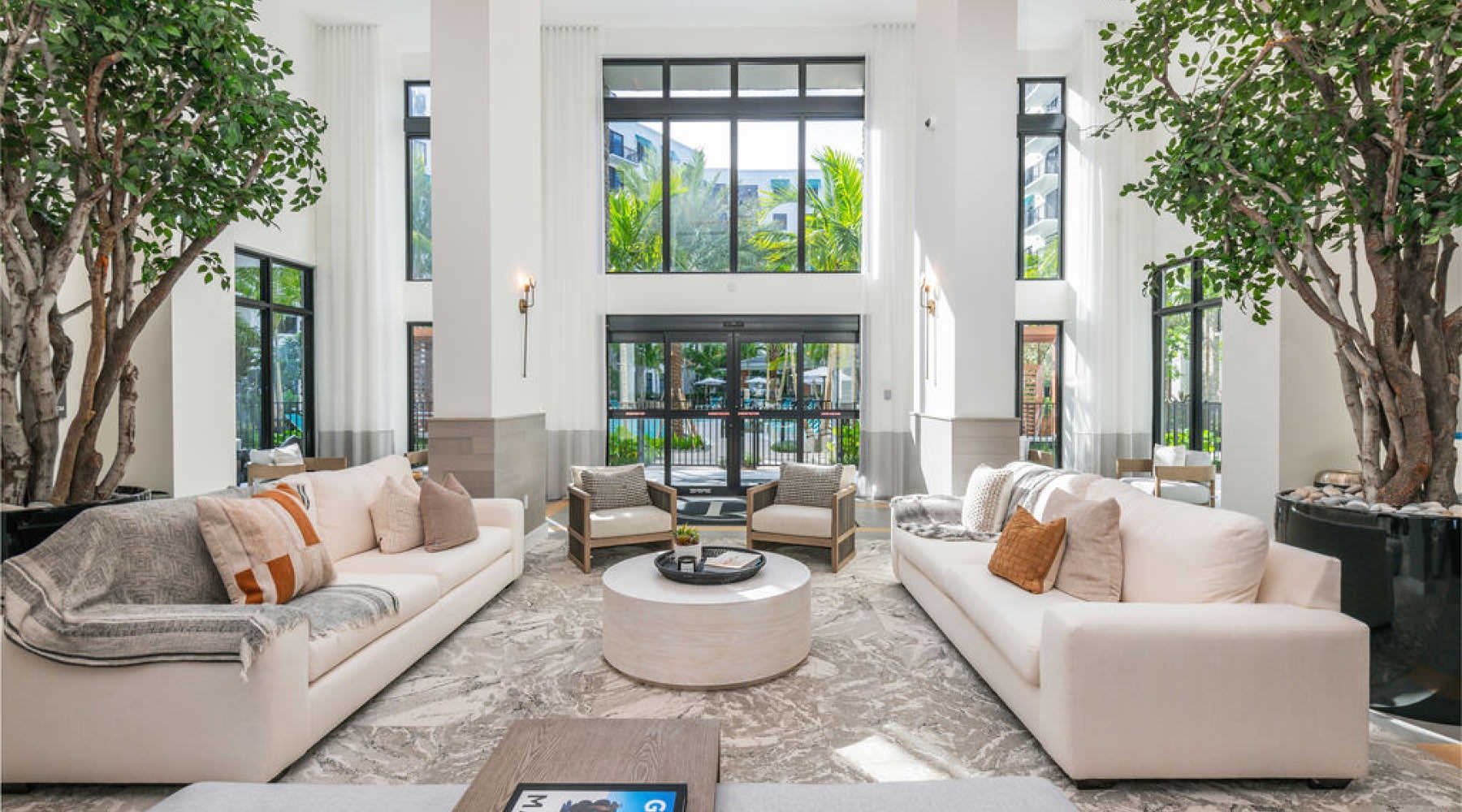 Experience the Best of Palm Beach sun filled lobby with planted trees
